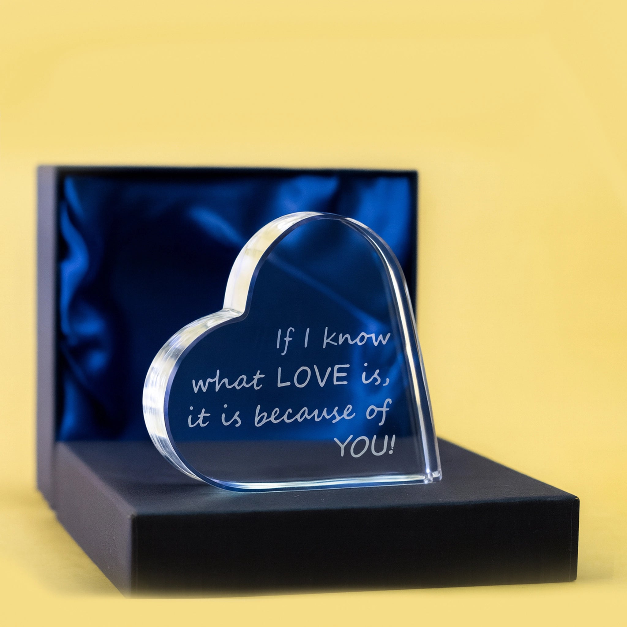 Heart-shaped glass plaque with engraved message in a box on a yellow background