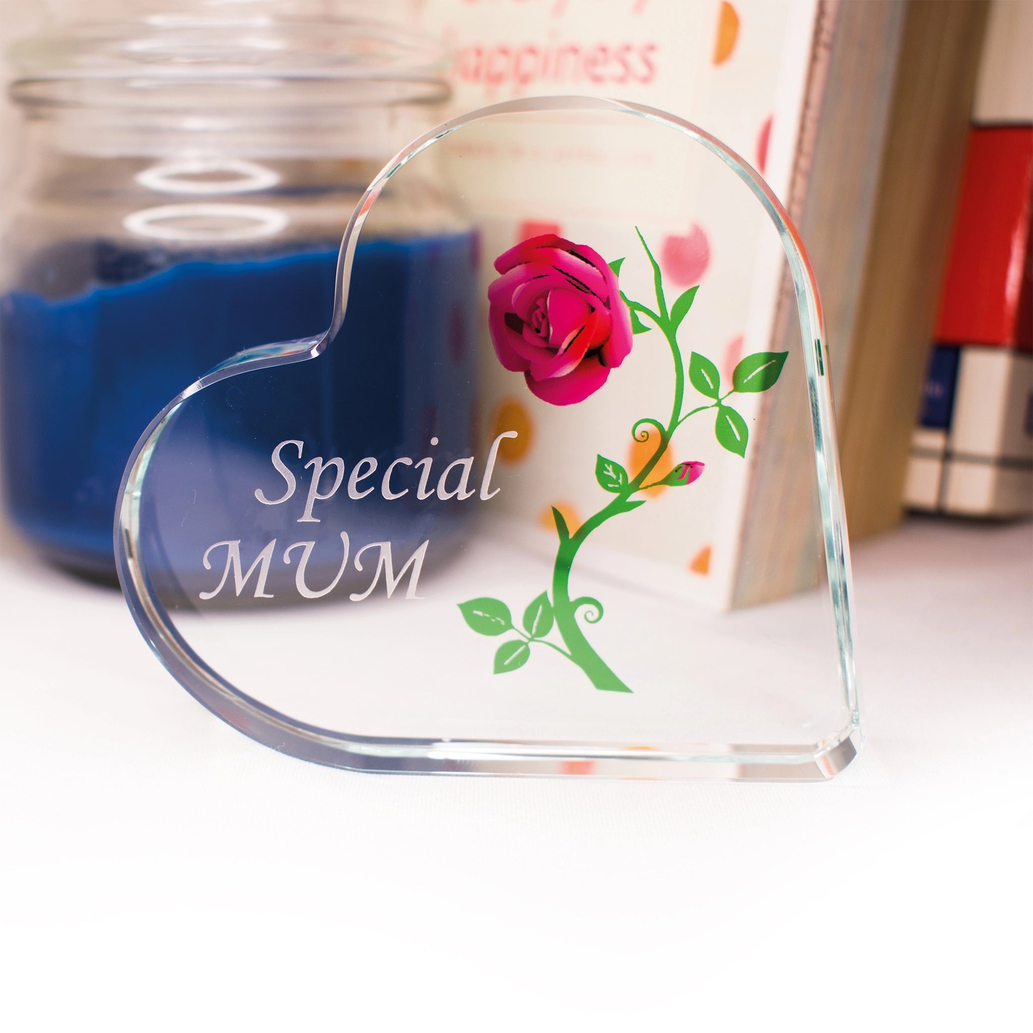 Heart-shaped glass ornament with 'Special MUM' text and floral design on a blurred background.